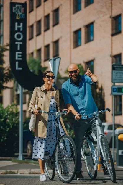 couple on bikes posing infront of one66 hotel